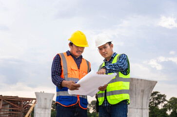 Engineer and foreman worker checking project at building site, Engineer and builders in hardhats...