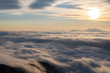 雲から透かして照らす朝日と雲海。日本の北海道の津別峠で。
