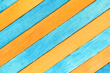 Fototapeta premium Alternating orange and blue diagonal wood panels. Two-tones wooden textured background. Wooden boards are painted blue and orange.