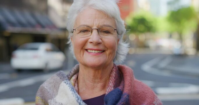 Smiling senior woman grinning and wearing optometry or optician prescription vision glasses to see downtown. Laughing lady showing a content and happy facial expression while standing in a busy city
