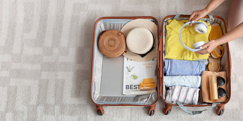 Woman packing suitcase at home, top view. Travel concept