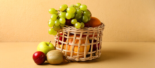 Basket with fresh fruits on beige background