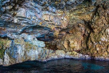 Boat trip view towards the famous caves of Votsi beach in Alonnisos island. Unique geological formation and rocky scenery in Sporades, Greece
