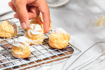 Choux cream, delicious pastries sprinkled with icing.