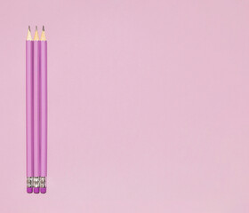 Wooden pastel purple pencils with erasers on purple background. Back to school concept. Monochromatic composition with copy space. Top view, flat lay.