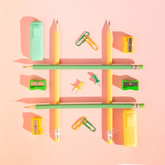 Wooden pencils on pastel pink background with school supplies, paper clips, felt pen and sharpener. Creative flat lay, top view. Back to school concept with stationery.