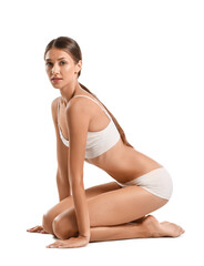 Young tanned woman in underwear sitting on white background