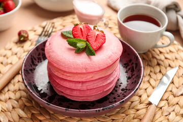 Bowl of tasty pancakes with strawberry on table, closeup