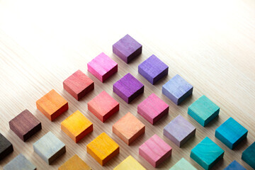 Colored wooden blocks arranged in a Pyramid pattern. Shallow depth of field.