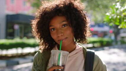 Portrait of an academic learner drinking takeaway coffee in the city before traveling to university. Edgy young female student sipping on a cold beverage while traveling and having fun in the city