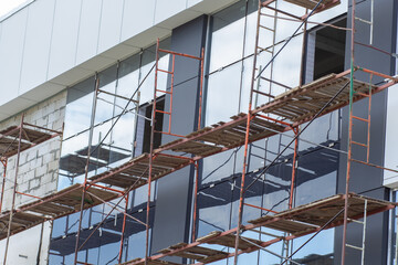 Metal scaffolding installed along the facade of building architecture for glazing facade and renew...