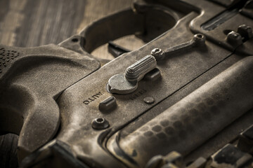 Close-up shot of selective fire of khaki camouflage M4 assault rifle, to be adjusted to fire in safe, semi-automatic, fully automatic firearm