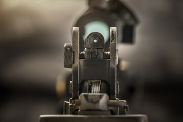 Close-up of flip rear sight and charging handle of assault rifle AR15 khaki camouflage - obrazy, fototapety, plakaty