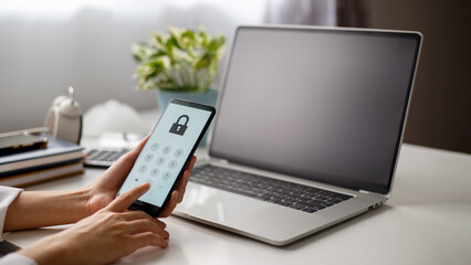 User holding mobile phone and pressing password on the screen to log in.