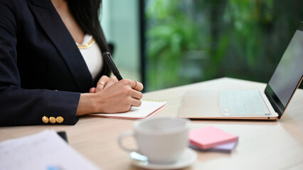Businesswoman or female executive manager writing or signing on the document - obrazy, fototapety, plakaty