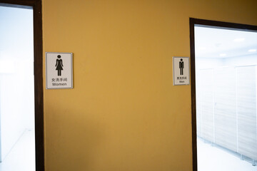 Outdoor public toilet and different signs.The men and women symbol on toilet wall.