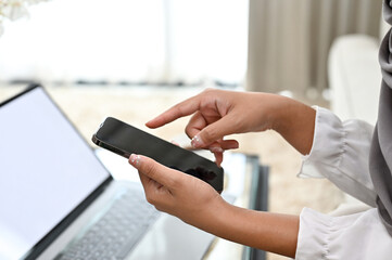A female hand holding smartphone, using mobile phone. cropped