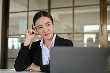 Fototapeta premium Smart and beautiful young Asian businesswoman thinking an ideas, working in the office.