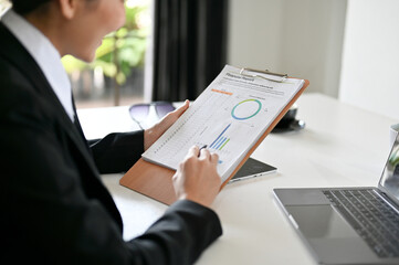 Female business financial worker reading and analysing a financial report