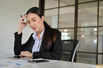 Serious young Asian businesswoman concentrated working on her financial project