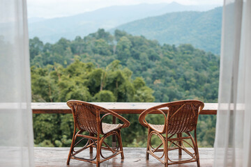 Couple chairs on balcony of countryside home or homestay with mountain view background in the morning