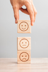 Man hand holding emotion face block. Customer choose Emoticon for user reviews. Service rating,...