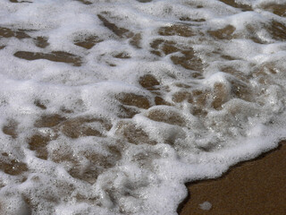 Close up of a wave crashing on a beach