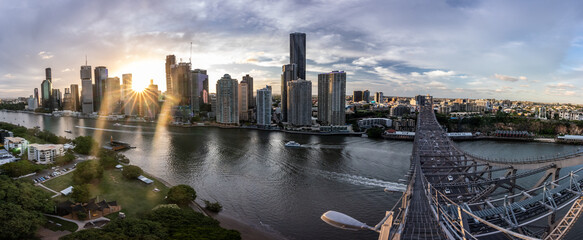 Brisbane city skyline viewed from the top of Story Bridge at sunset with glowing river and urban skyscrapers