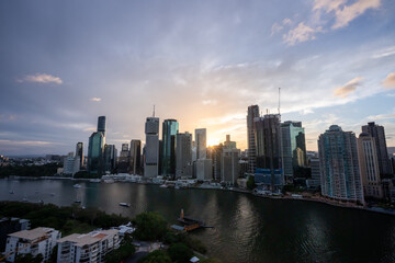 Brisbane city skyline viewed from the top of Story Bridge at sunset with glowing river and urban skyscrapers