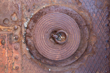 Texture and background of circular rusty metal lid with ring to open