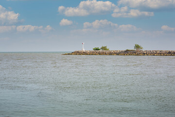 Fototapeta premium The lighthouse sits on a rocky outcrop in the sea on a clear day.