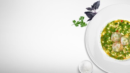 Okroshka, summer, cold soup with vegetables, fresh herbs and kefir in a bowl