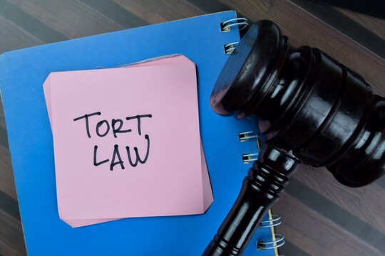 Concept Of Tort Law Write On Sticky With Gavel Notes Isolated On Wooden Table.