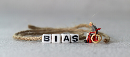 Business concept with white cube arranged in the word  ’BIAS' and miniature people. The concept...