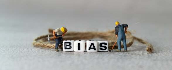 Business concept with white cube arranged in the word  ’BIAS' and miniature people. The concept...