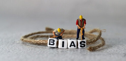 Business concept with white cube arranged in the word  ’BIAS' and miniature people. The concept of not being prejudiced.
 - obrazy, fototapety, plakaty