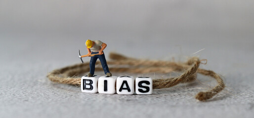 Business concept with white cube arranged in the word  ’BIAS' and miniature people. The concept of not being prejudiced.
