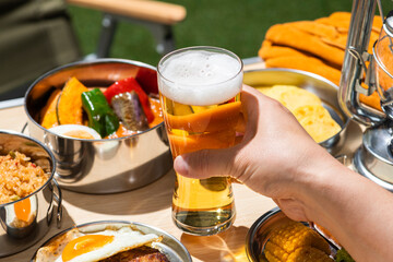 夏のアウトドアキャンプでビールを飲む