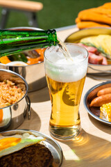 アウトドアのキャンプのテーブルに並んだ食事とビール