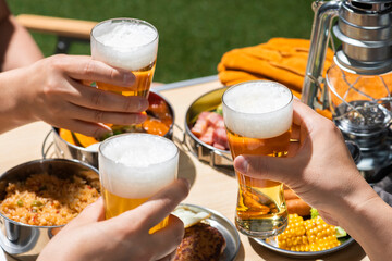 夏のアウトドアキャンプでビールを飲む