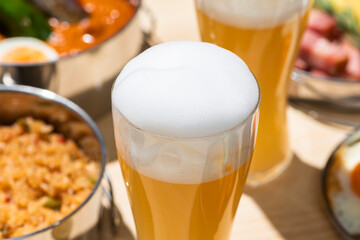 アウトドアのキャンプのテーブルに並んだ食事とビール