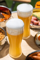 アウトドアのキャンプのテーブルに並んだ食事とビール