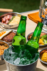 アウトドアのキャンプのテーブルに並んだ食事とビール