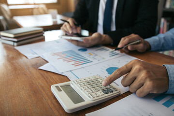 Two business partnership coworkers analysis strategy with discussing a financial planning graph and company budget during a budget meeting in office room.
