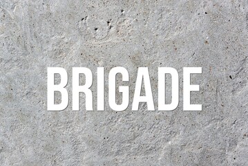 BRIGADE - word on concrete background. Cement floor, wall.