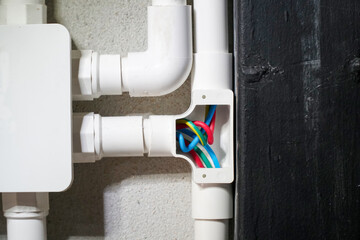 Electrician open cap of PVC inspection tee fitting on wall