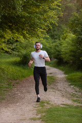 Athletic sports man trail running in the forest. Active healthy lifestyle. Male jogger jogging in...