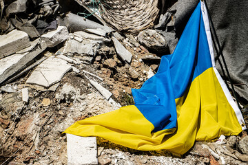 Ukrainian flag in the ruins of a demolished house