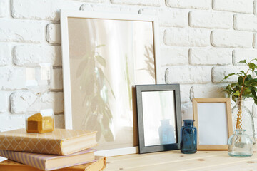 Wooden frame mockup on table with modern vase and books