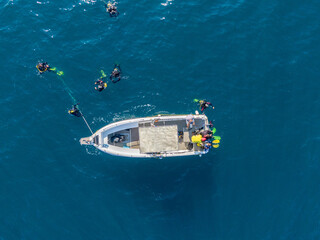 Group of scuba divers jumping from a boat